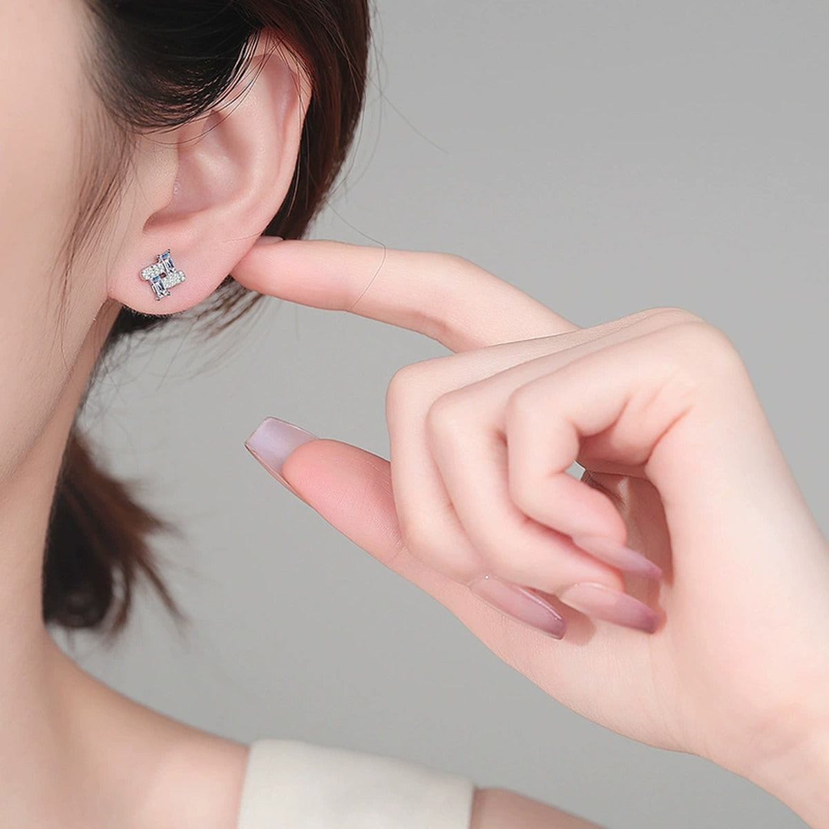 Emerald-Cut Moissanite Geometric Stud Earrings with CZ in Gold-Plated S925 sterling silver worn on ear by model showing scale, placement, and stud earrings styling
