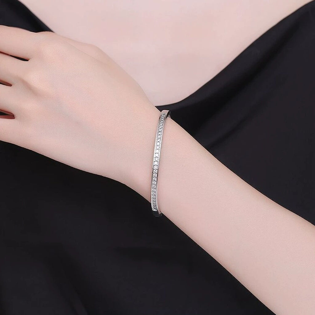 Round Moissanite Eternity Bangle in White Gold-Plated S925 sterling silver worn on wrist model view showing scale and adjustable fit