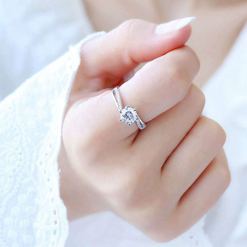 Twist Six-Prong Round Moissanite Engagement Ring with CZ worn on hand to show scale, band width, and ring profile