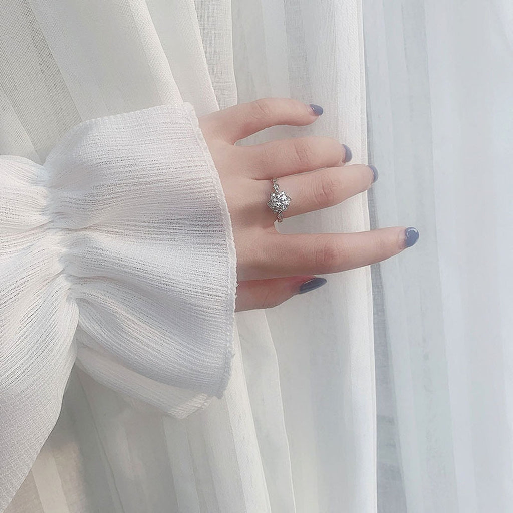 Floral Round Moissanite Adjustable Engagement Ring with CZ worn on hand to show scale, band width, and ring profile