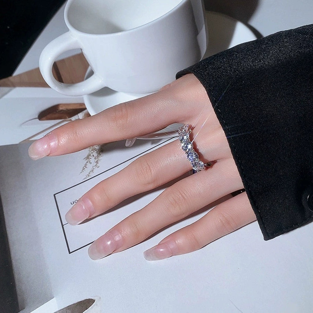 Graduated Round Moissanite Wedding Ring worn on hand to show scale, band width, and ring profile