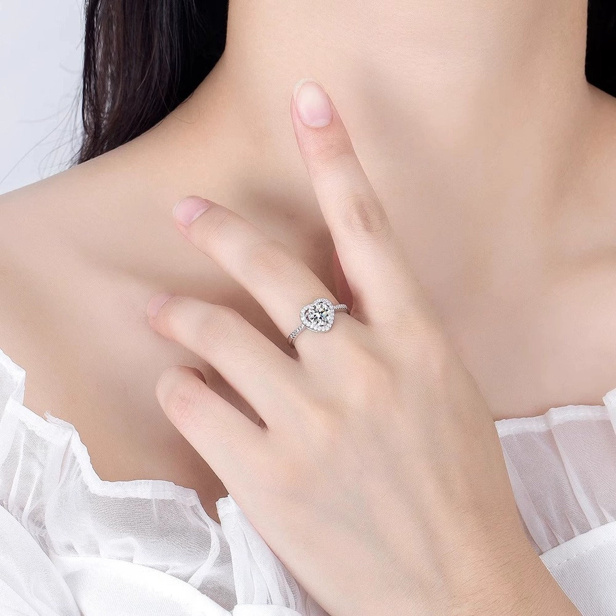 Heart Motif Round Moissanite Adjustable Engagement Ring with CZ worn on hand to show scale, band width, and ring profile