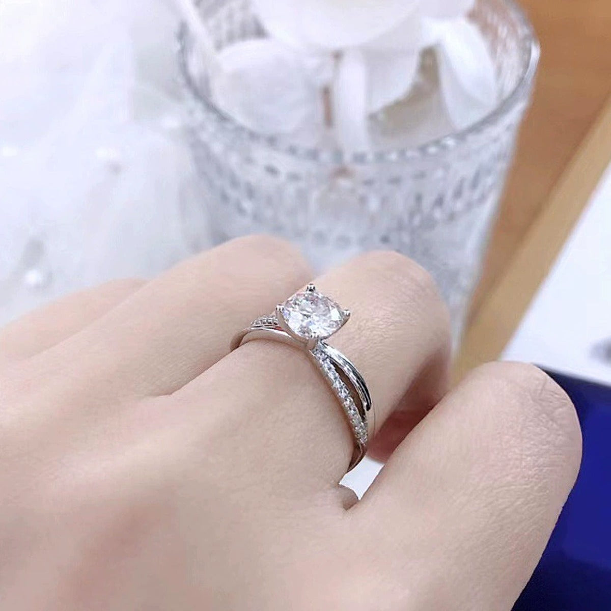 Cross-Band Four-Prong Round Moissanite Adjustable Engagement Ring with CZ worn on hand to show scale, band width, and ring profile