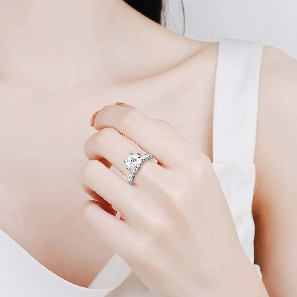 Six-Prong Round Moissanite Engagement Ring with CZ worn on hand to show scale, band width, and ring profile