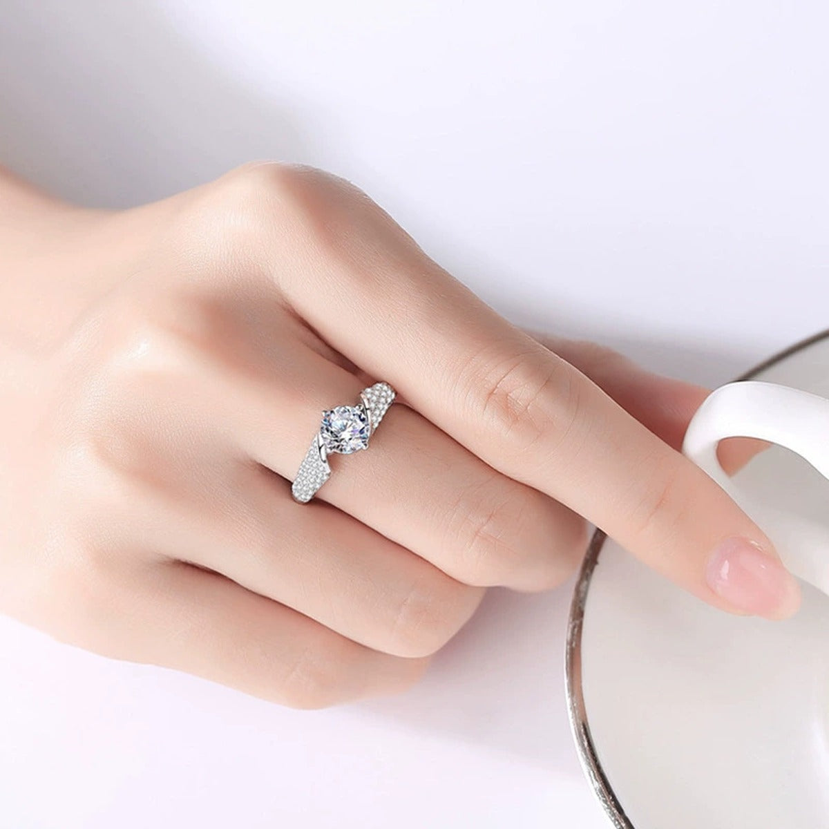 Four-Prong Round Moissanite Wedding Ring with CZ worn on hand to show scale, band width, and ring profile