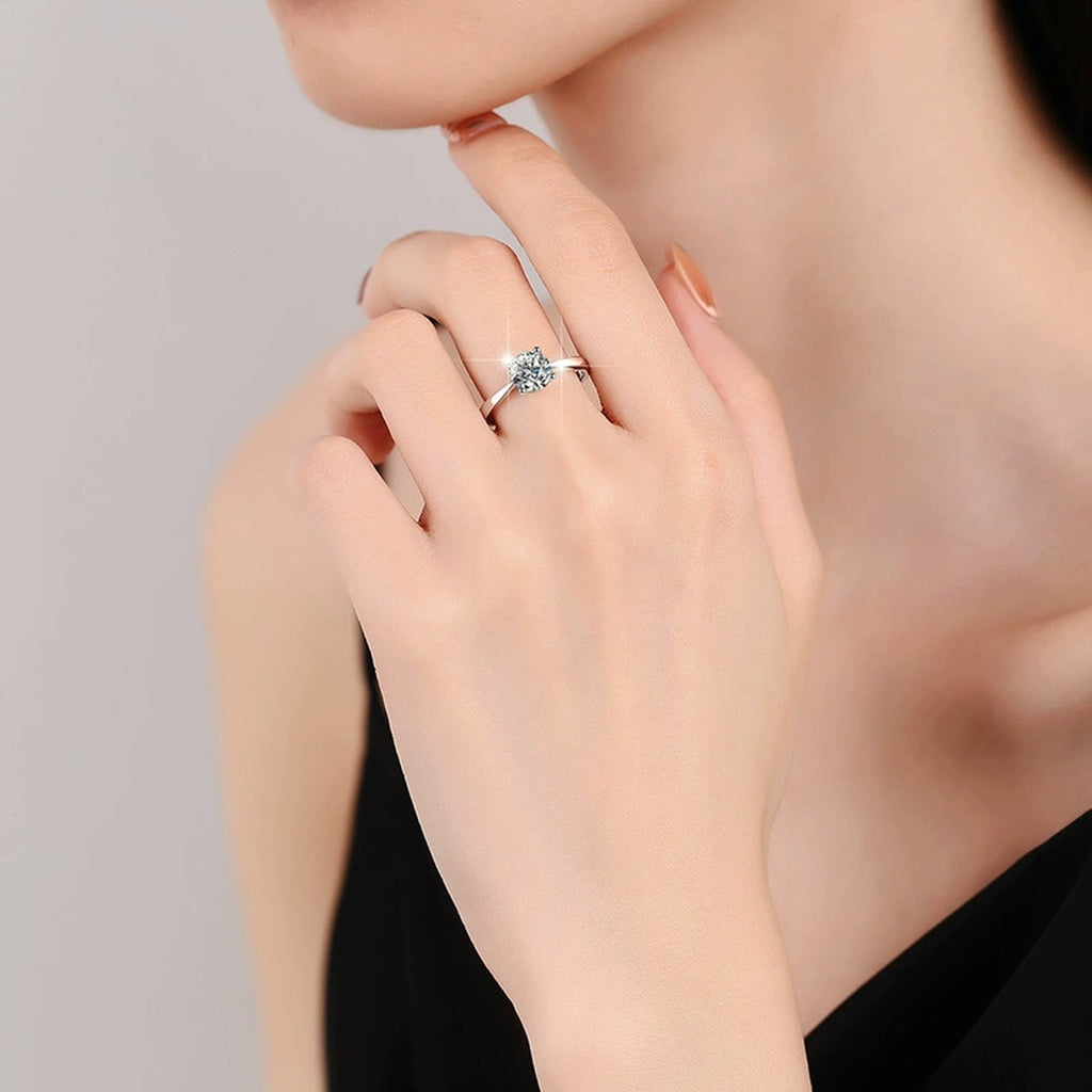 Four-Prong Round Moissanite Adjustable Solitaire Engagement Ring worn on hand to show scale, band width, and ring profile