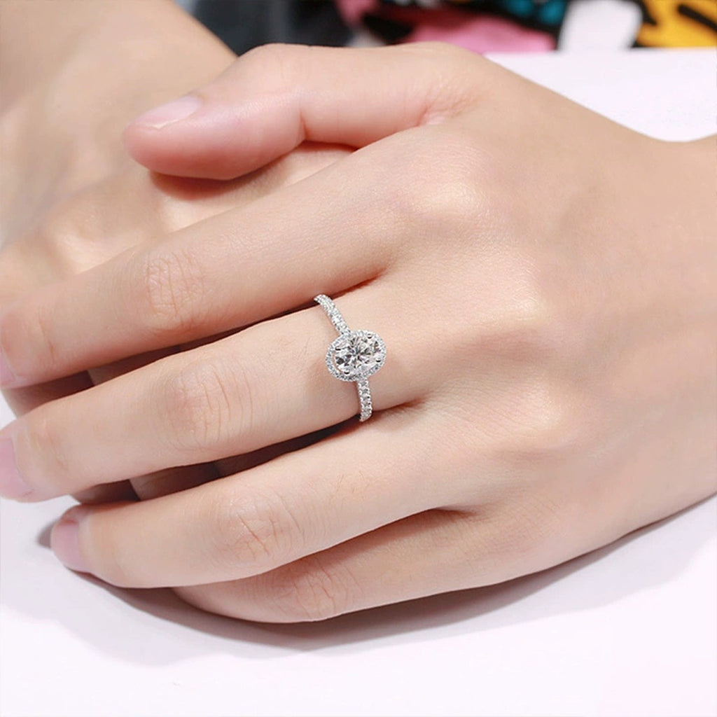 Four-Prong Oval Moissanite Adjustable Engagement Ring with CZ worn on hand to show scale, band width, and ring profile