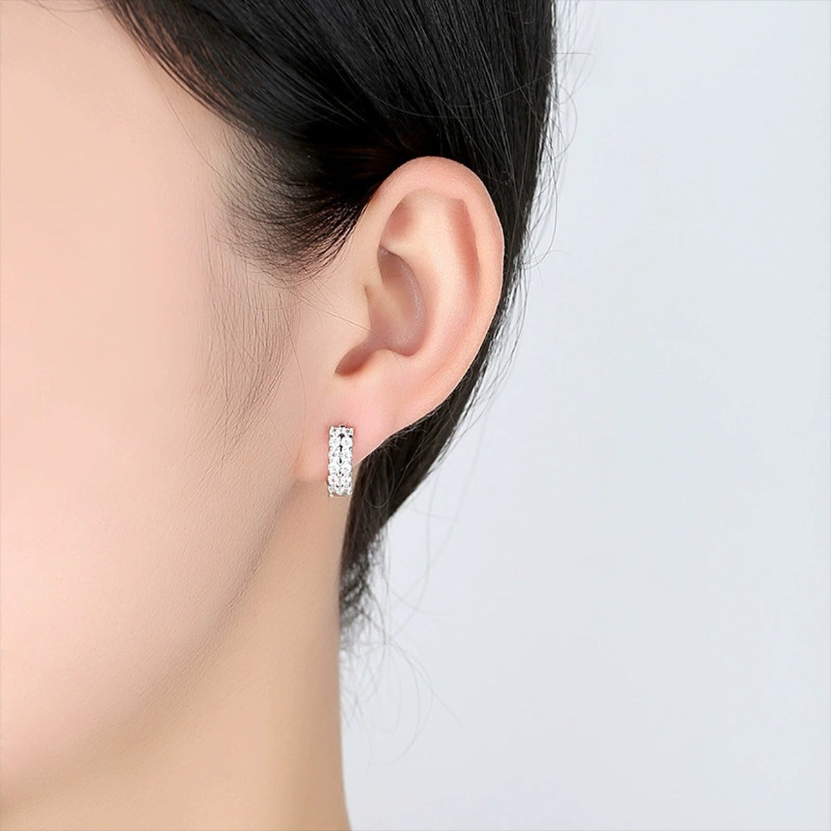 Three-Row Round Moissanite Huggie Hoop Earrings in White Gold-Plated S925 sterling silver worn on ear by model showing scale, placement, and huggie hoop earrings styling