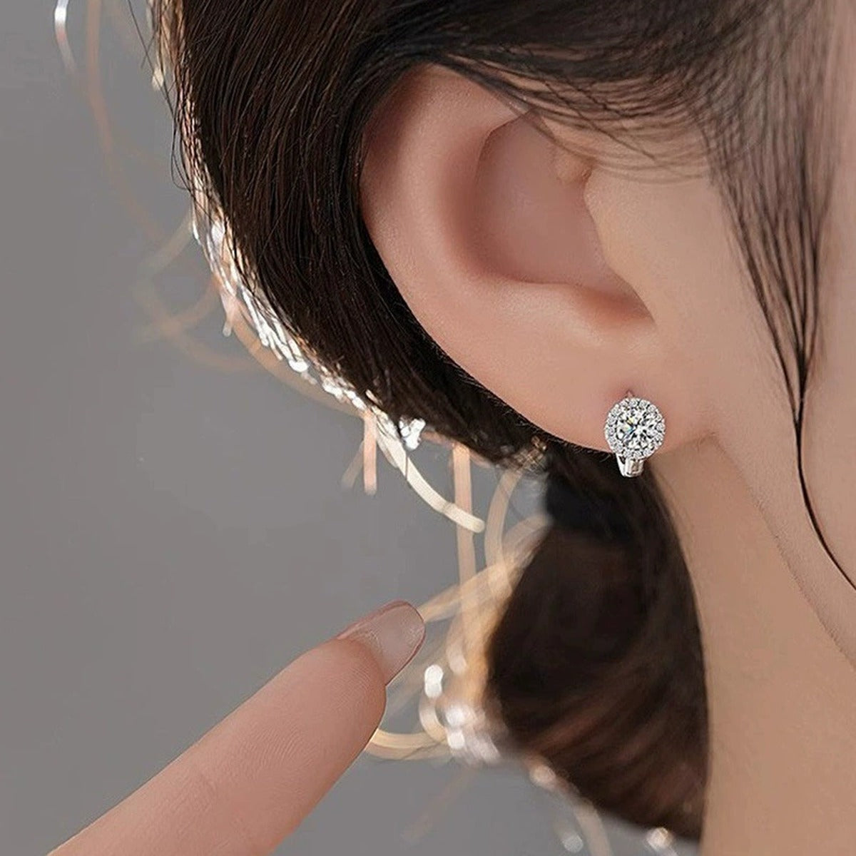Round Moissanite Halo Huggie Hoop Earrings with CZ in White Gold-Plated S925 sterling silver worn on ear by model showing scale, placement, and huggie hoop earrings styling