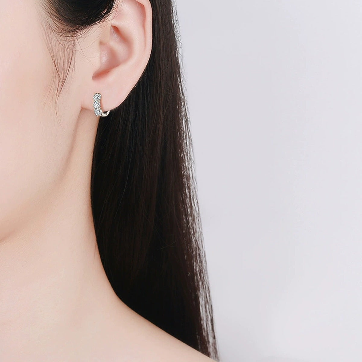 Floral Cluster Round Moissanite Huggie Hoop Earrings in White Gold-Plated S925 sterling silver worn on ear by model showing scale, placement, and huggie hoop earrings styling