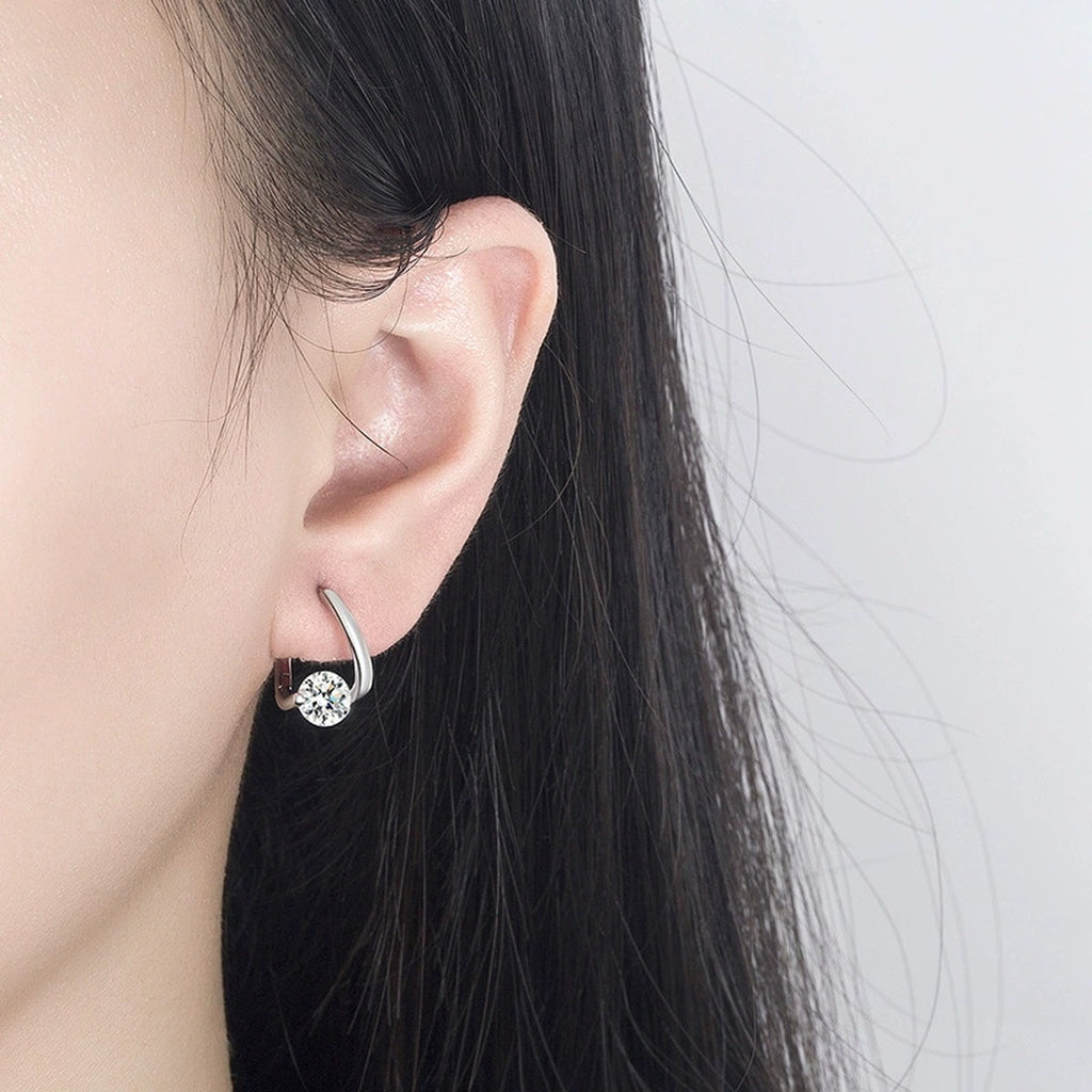 Round Moissanite Huggie Hoop Earrings in White Gold-Plated S925 sterling silver worn on ear by model showing scale, placement, and huggie hoop earrings styling