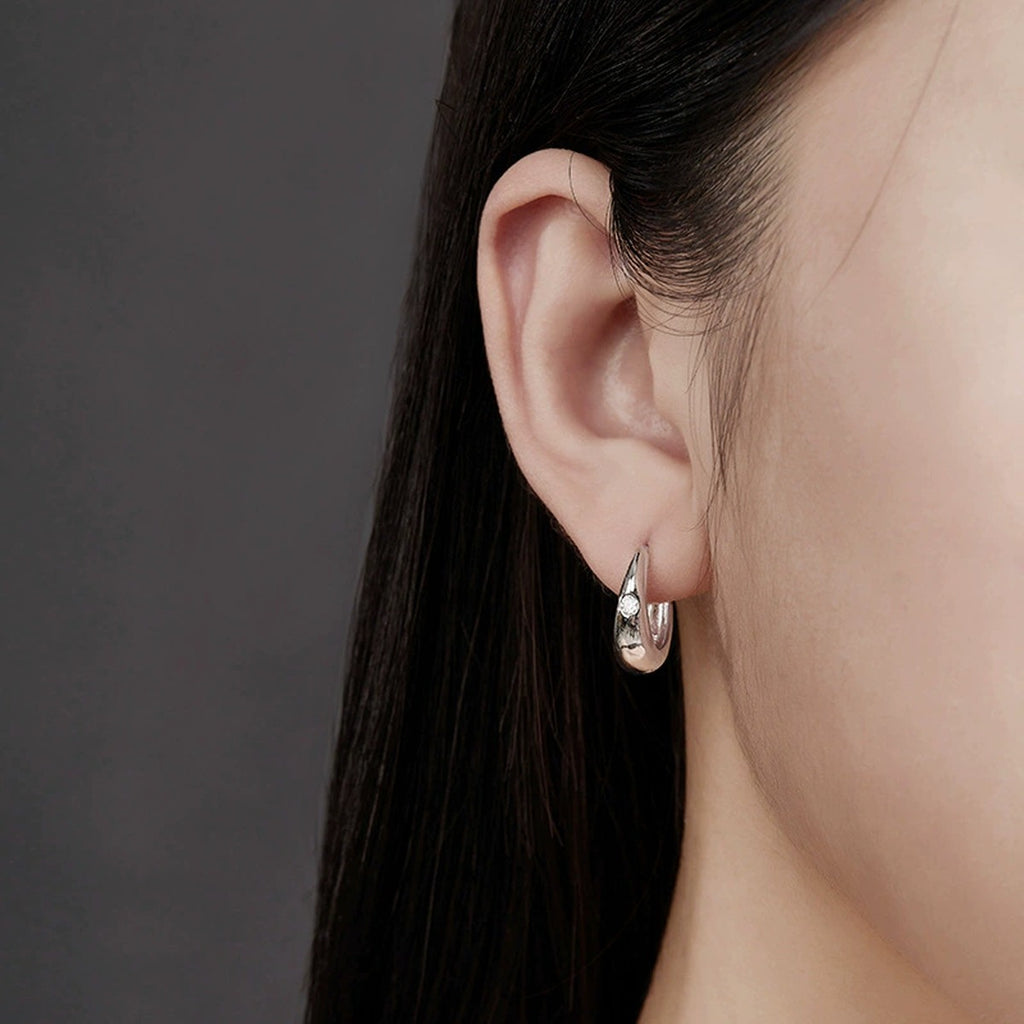 Polished Round Moissanite Hoop Earrings in White Gold-Plated S925 sterling silver worn on ear by model showing scale, placement, and hoop earrings styling