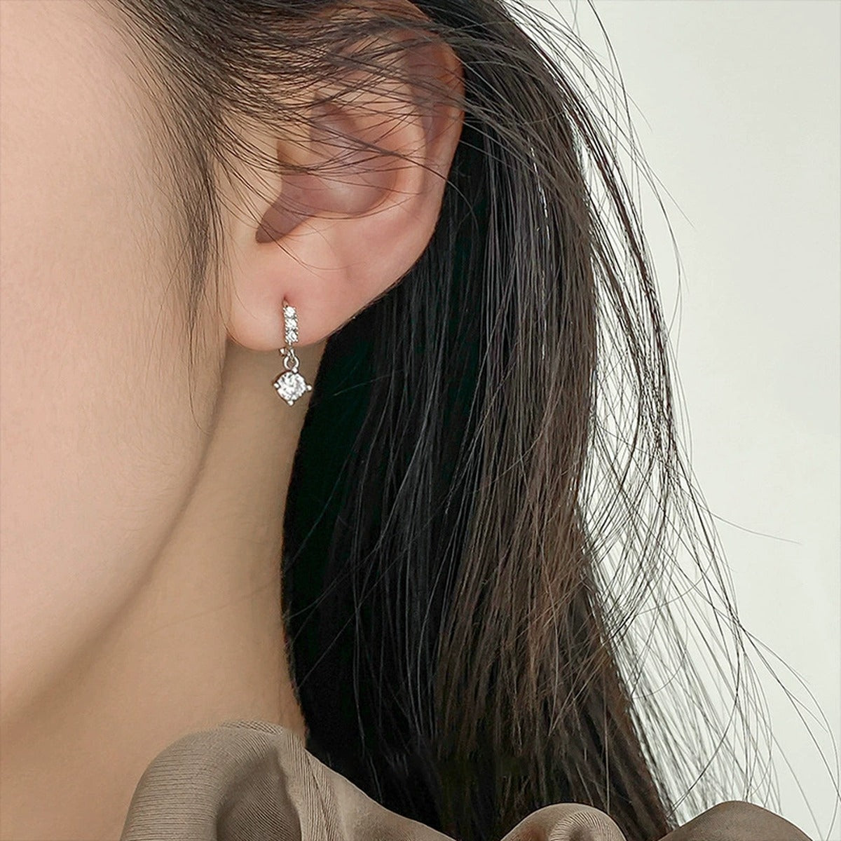 Graduated Round Moissanite Hoop Dangle Earrings with CZ in White Gold-Plated S925 sterling silver worn on ear by model showing scale, placement, and hoop dangle earrings styling