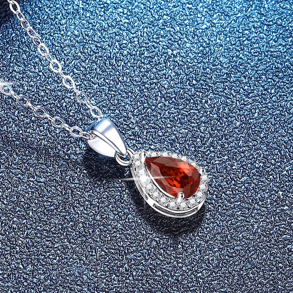 Oval Lab-Grown Gemstone and Moissanite Pendant Necklace in White Gold-Plated S925 Sterling Silver blue background angled view