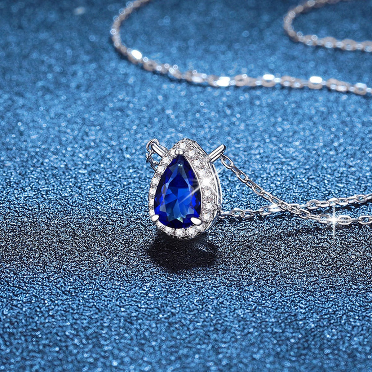 Pear Lab-Grown Gemstone and Moissanite Pendant Necklace in White Gold-Plated S925 Sterling Silver blue background angled view