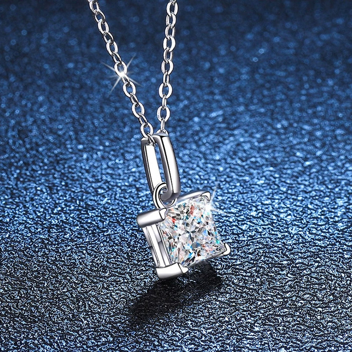 Cushion Moissanite Pendant Necklace in White Gold-Plated S925 Sterling Silver blue background angled view