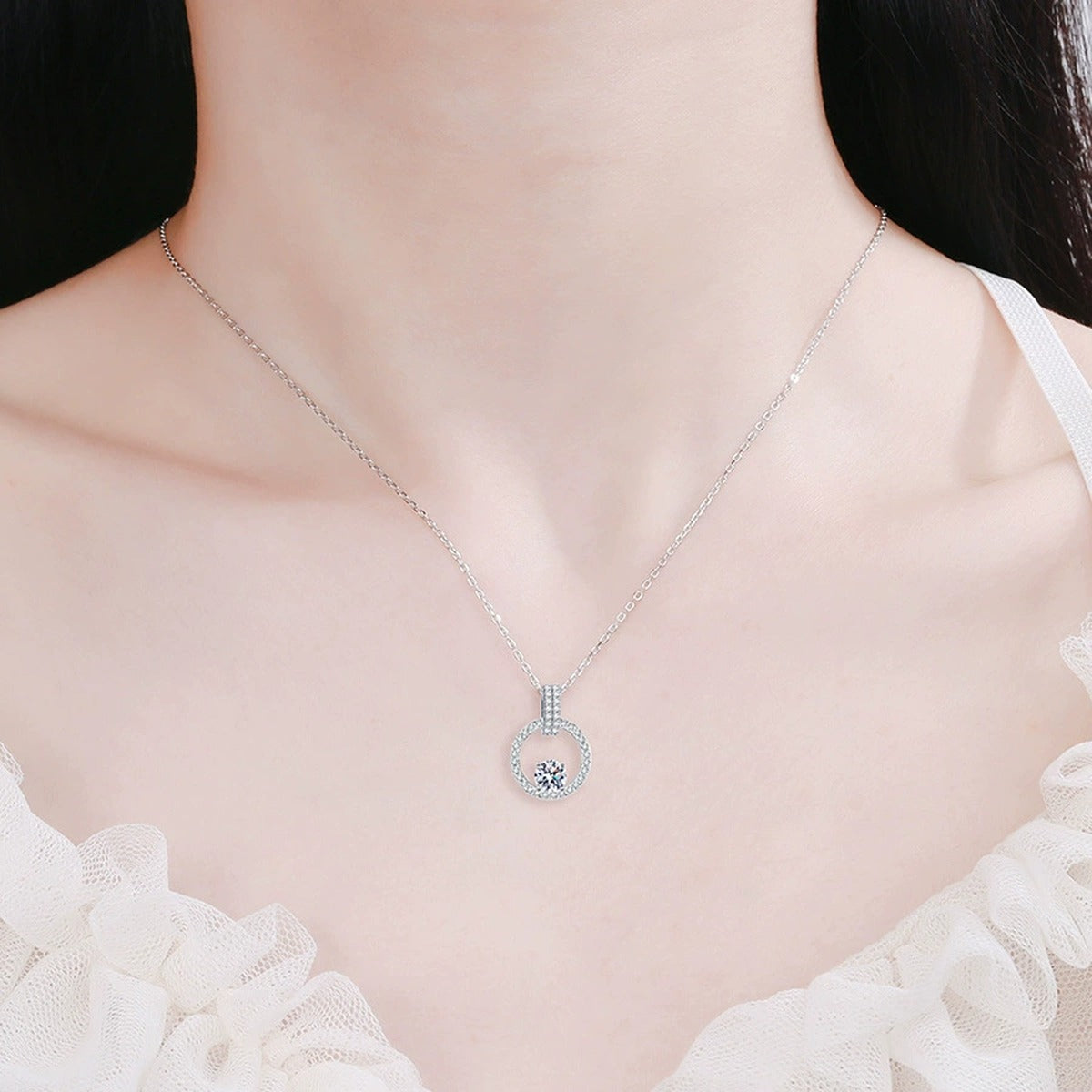 circle halo moissanite pendant necklace with CZ accents in platinum-plated S925 sterling silver worn by model