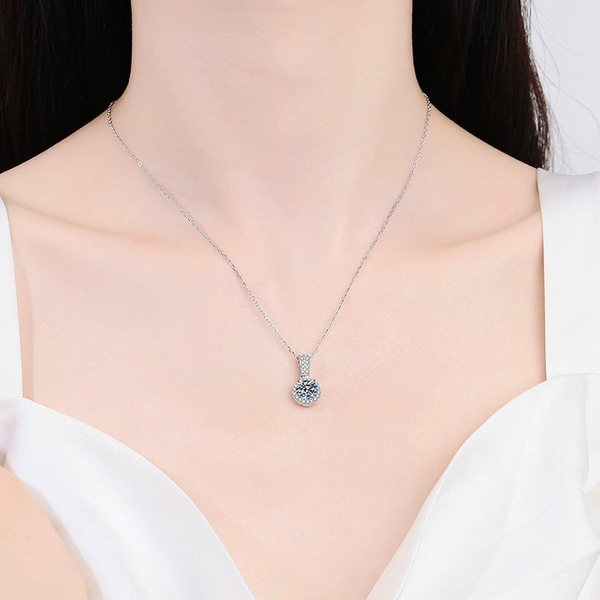 round halo moissanite pendant necklace with CZ accents in platinum-plated S925 sterling silver worn by model