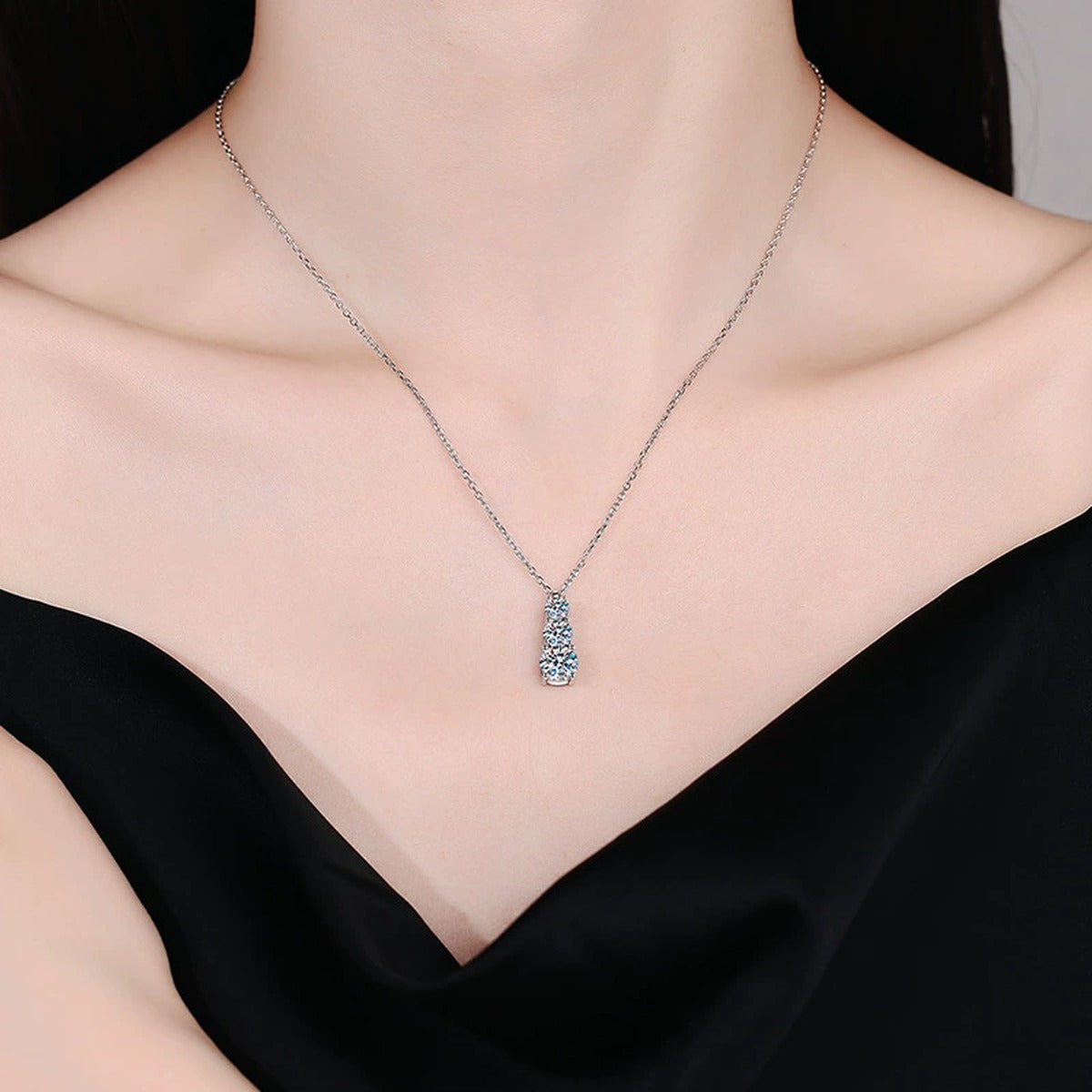 Graduated Three-Stone Moissanite Drop Necklace in Platinum-Plated S925 Sterling Silver worn by model at neckline