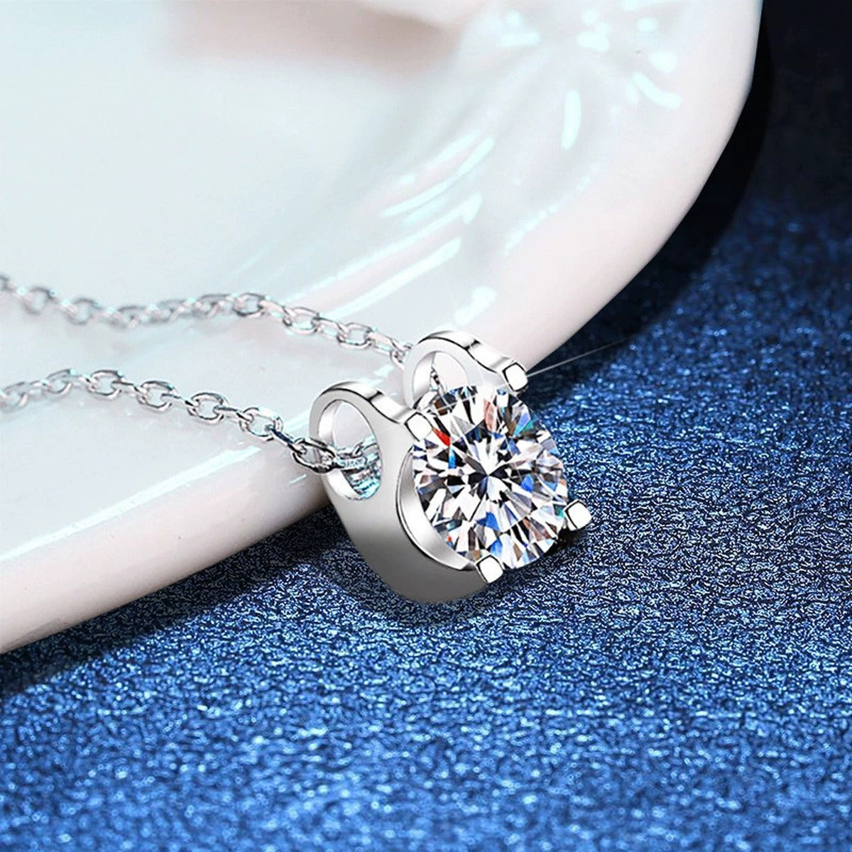 Round Moissanite Solitaire Pendant Necklace in White Gold-Plated S925 Sterling Silver blue background angled detail view