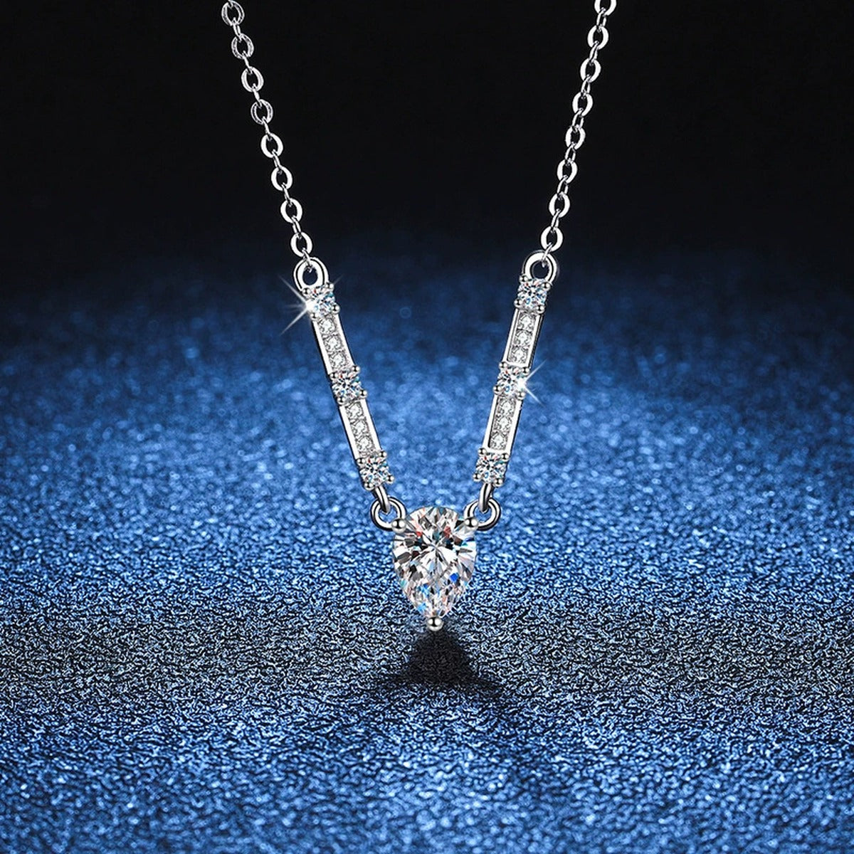 Pear Moissanite Bar Drop Necklace in Platinum-Plated S925 Sterling Silver blue background angled detail view