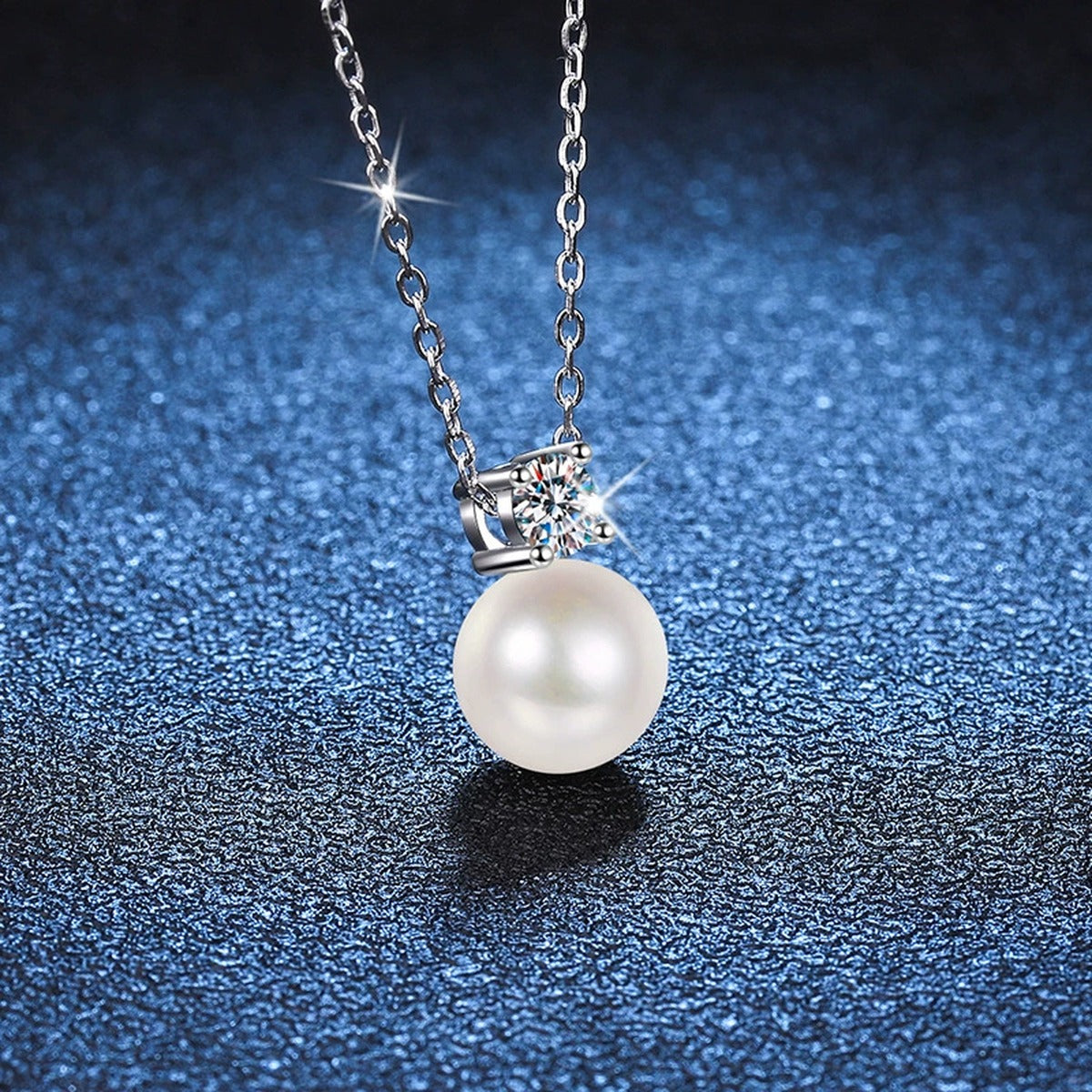 Petite Round Moissanite Pendant Necklace in Platinum-Plated S925 Sterling Silver blue background close-up view