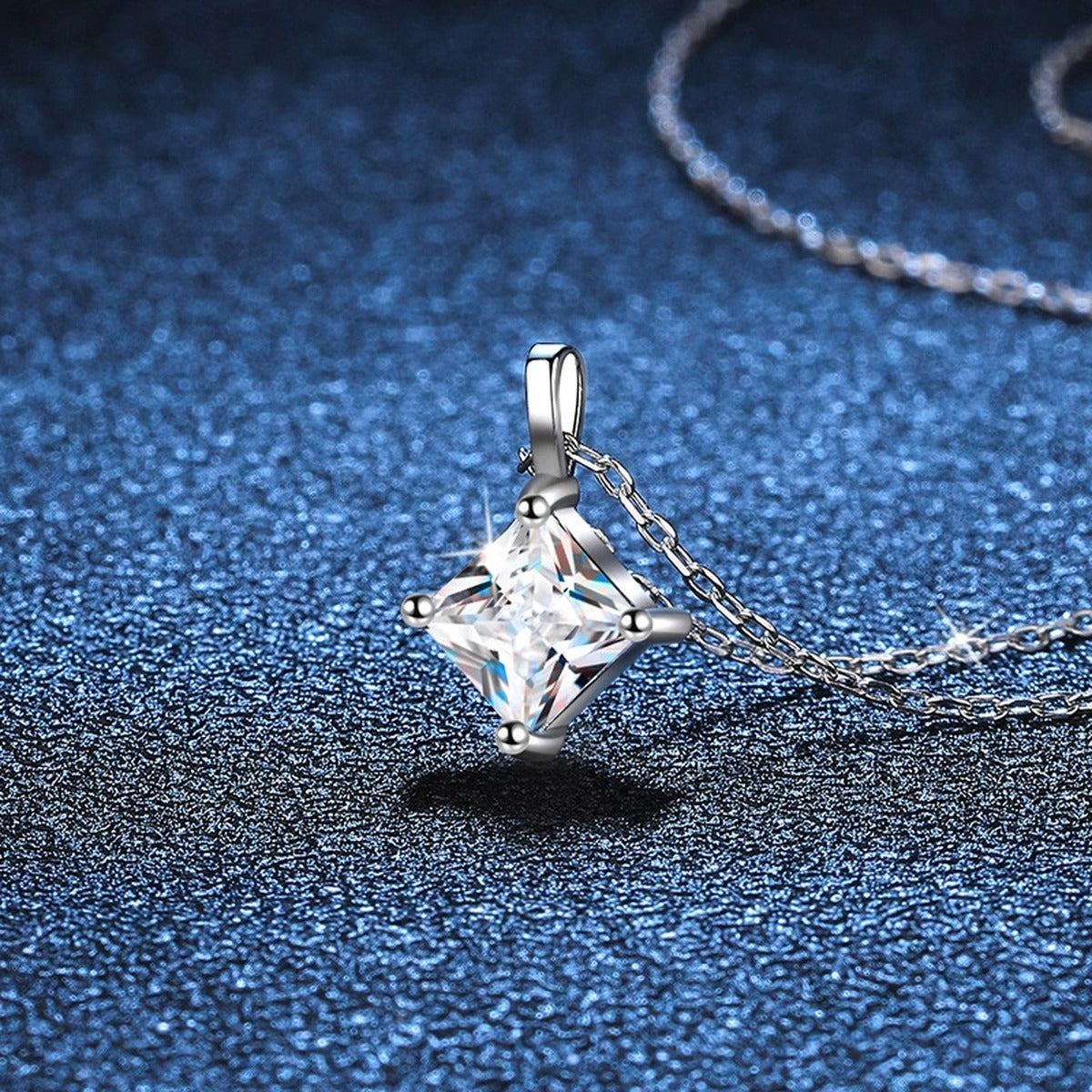 Princess-Cut Moissanite Pendant Necklace in Platinum-Plated S925 Sterling Silver blue background angled detail view
