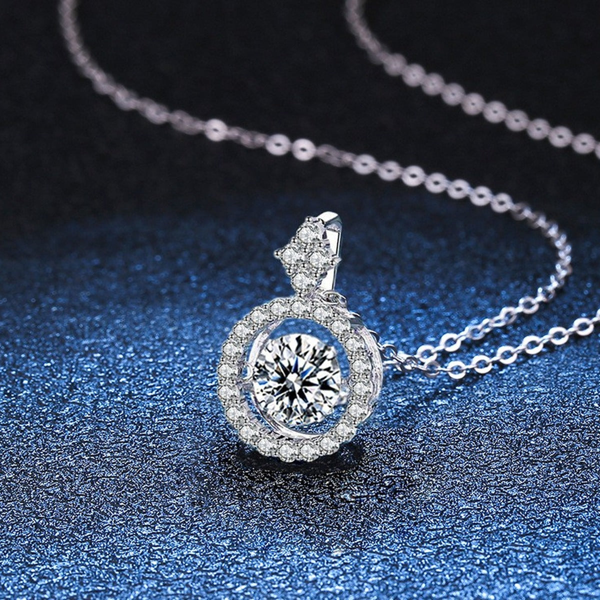 Round Halo Moissanite Pendant Necklace in Platinum-Plated S925 Sterling Silver blue background angled detail view