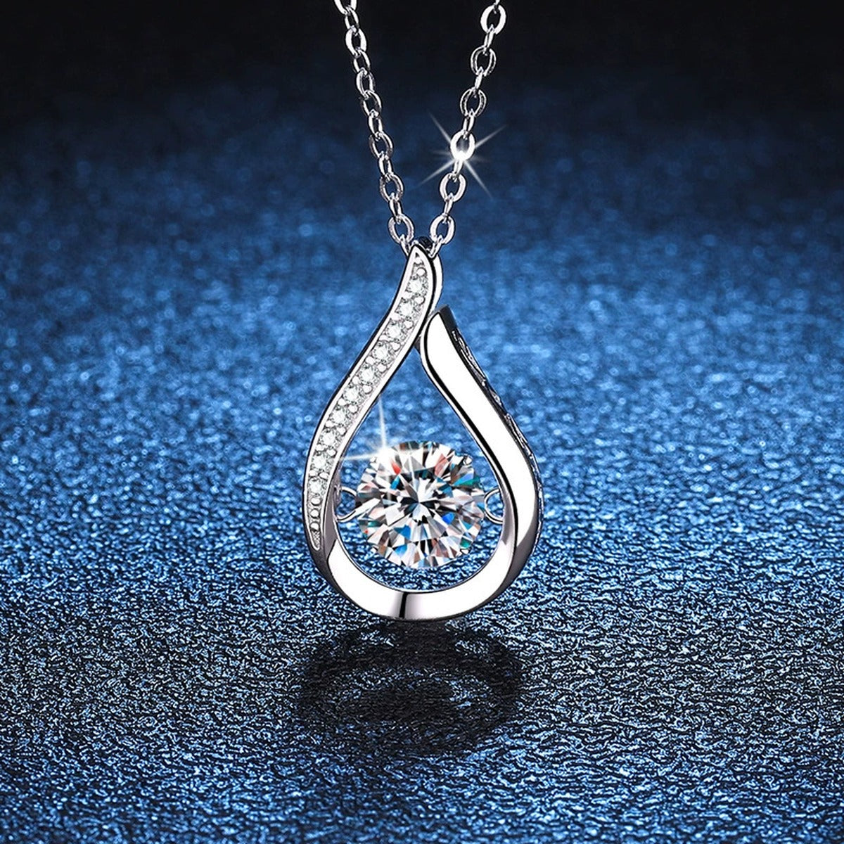 Teardrop Moissanite Pendant Necklace in Platinum-Plated S925 Sterling Silver blue background angled detail view