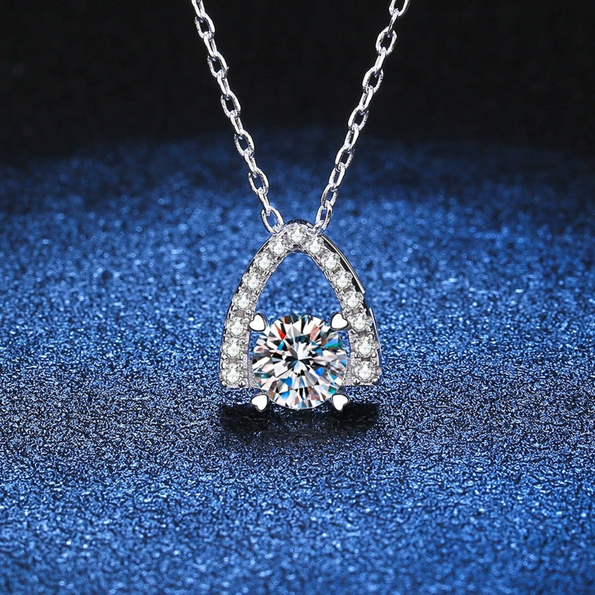 Arch Halo Moissanite Pendant Necklace in Platinum-Plated S925 Sterling Silver blue background angled detail view