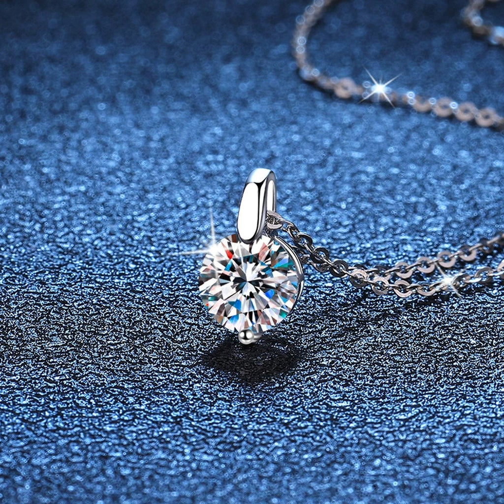 Round Moissanite Solitaire Pendant Necklace in Platinum-Plated S925 Sterling Silver blue background close-up view