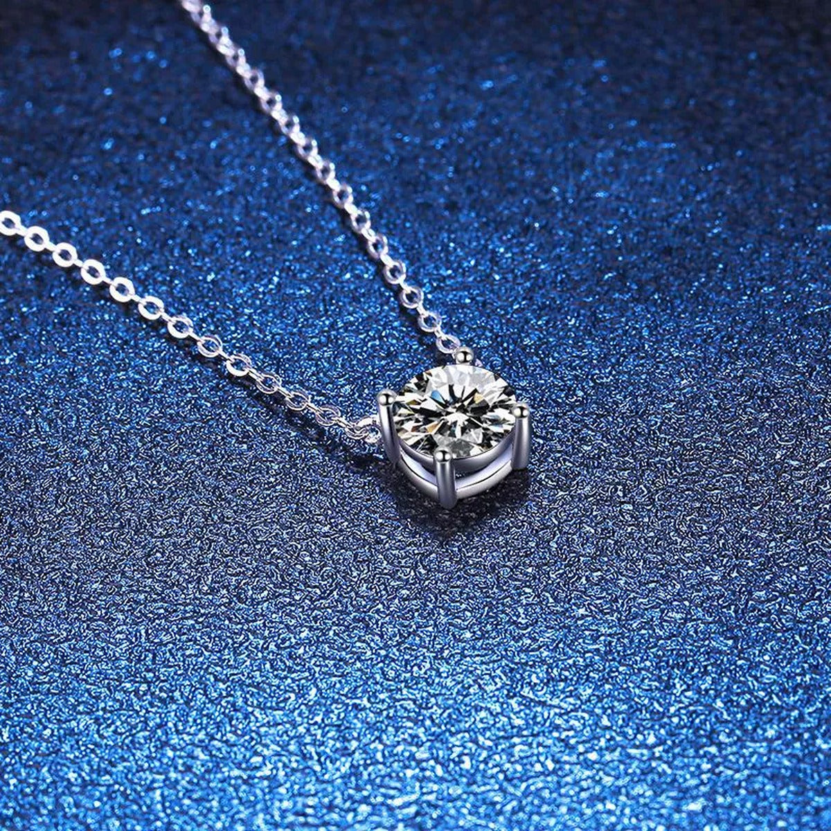 Round Moissanite Solitaire Pendant Necklace in Platinum-Plated S925 Sterling Silver blue background close-up view