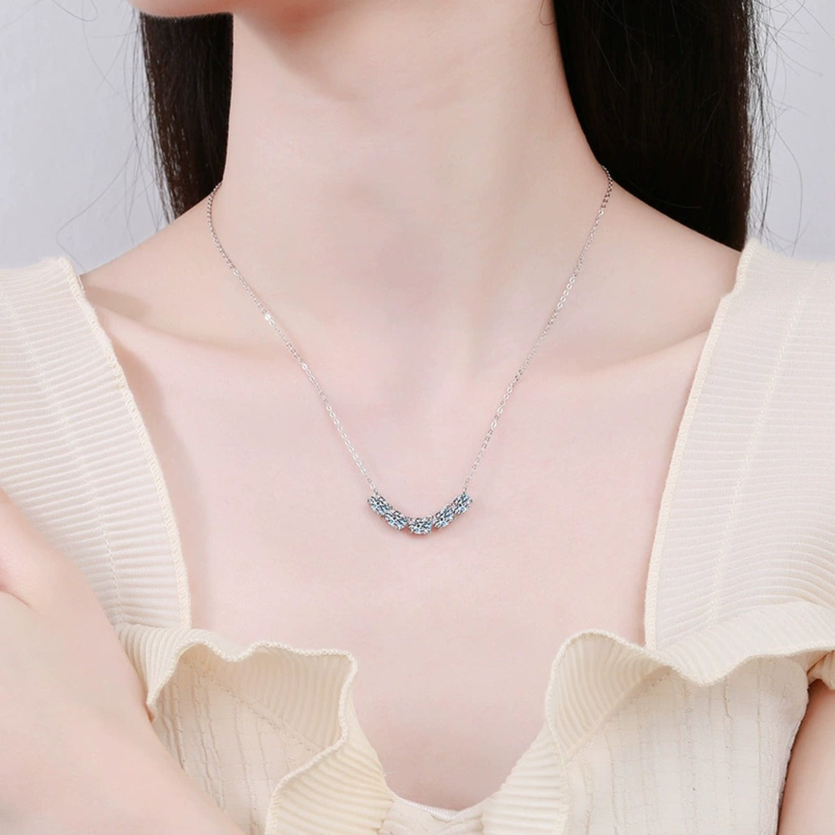 Graduated Five-Stone Moissanite Necklace in Platinum-Plated S925 Sterling Silver worn on neckline by model