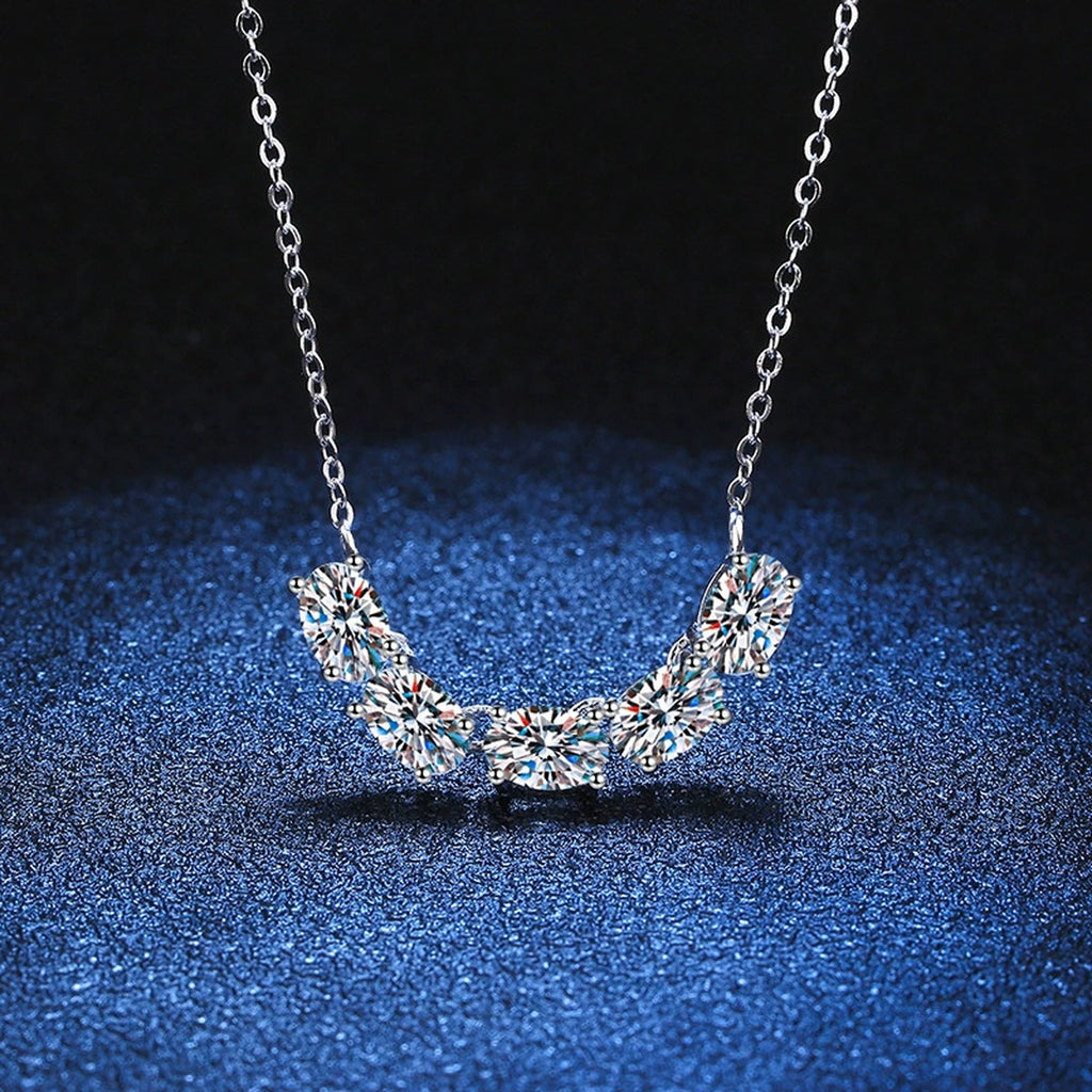 Graduated Five-Stone Moissanite Necklace in Platinum-Plated S925 Sterling Silver blue background close-up view