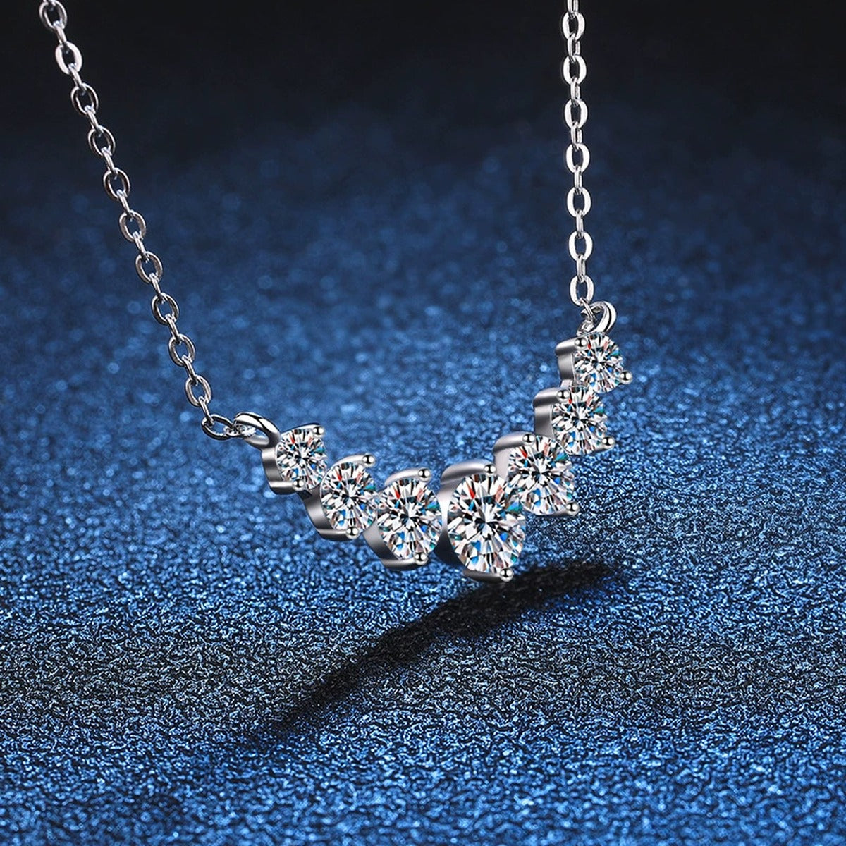 Graduated Moissanite Collar Necklace in Platinum-Plated S925 Sterling Silver blue background angled detail view