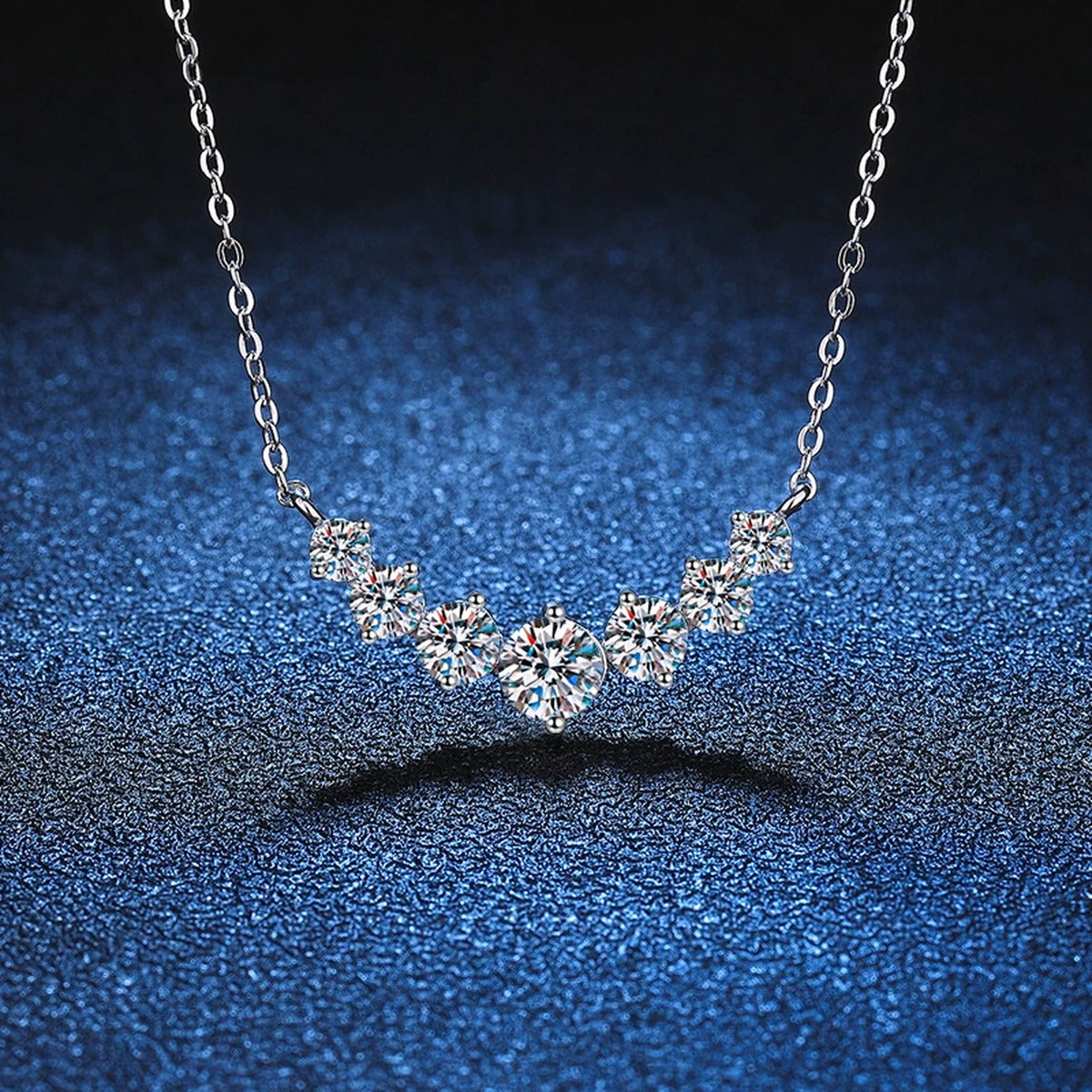 Graduated Moissanite Collar Necklace in Platinum-Plated S925 Sterling Silver blue background close-up view