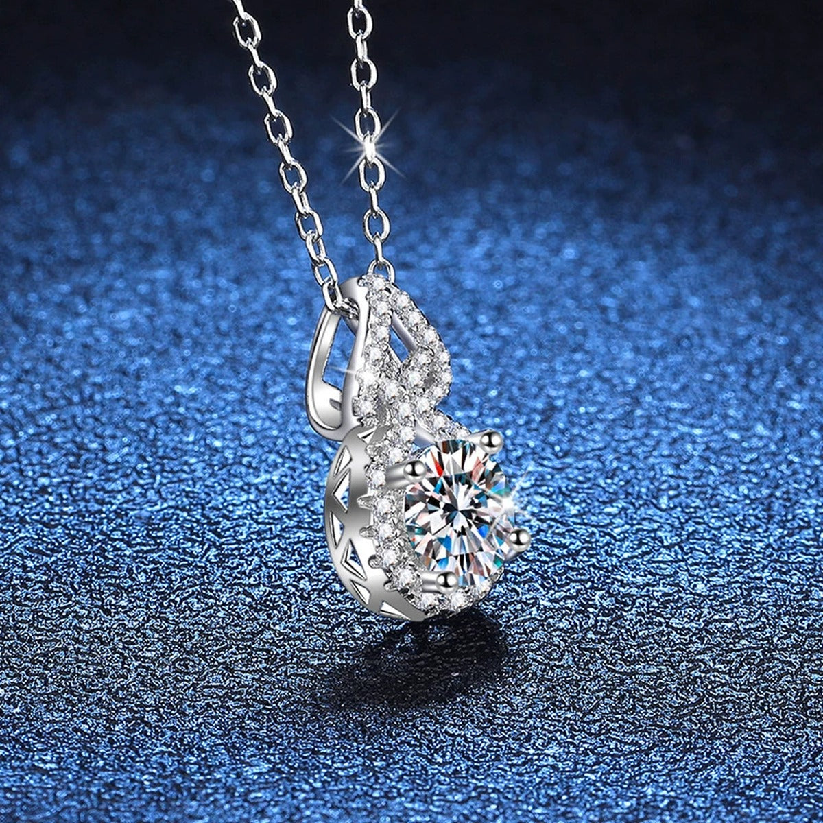 Pear Halo Moissanite Drop Necklace in Platinum-Plated S925 Sterling Silver blue background angled detail view