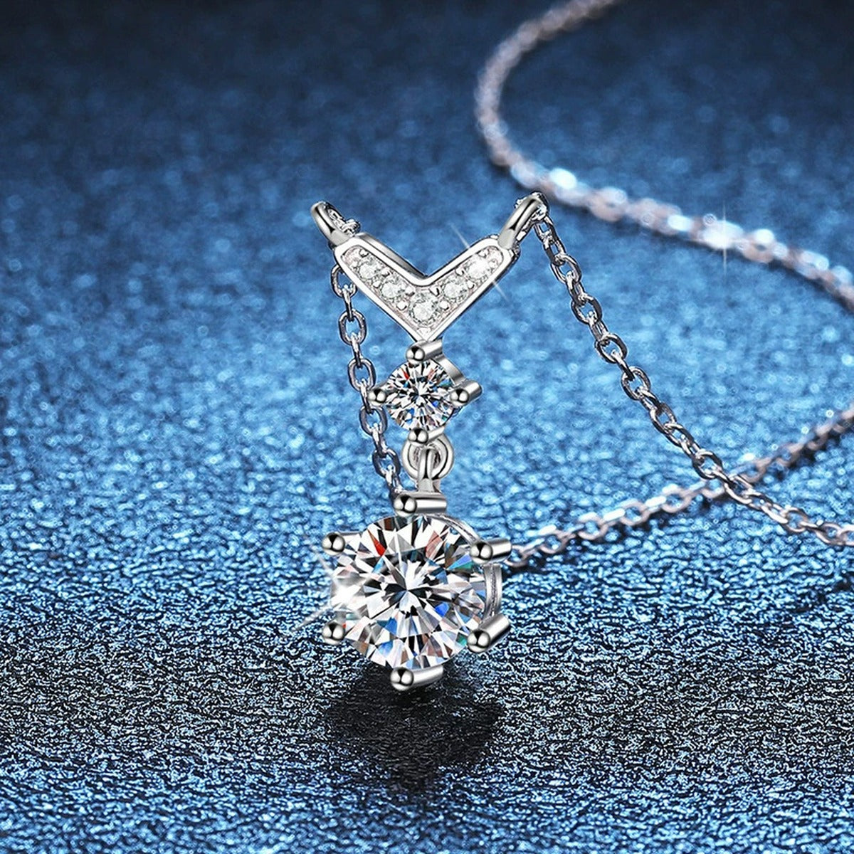 Chevron Drop Moissanite Necklace in Platinum-Plated S925 Sterling Silver blue background angled detail view