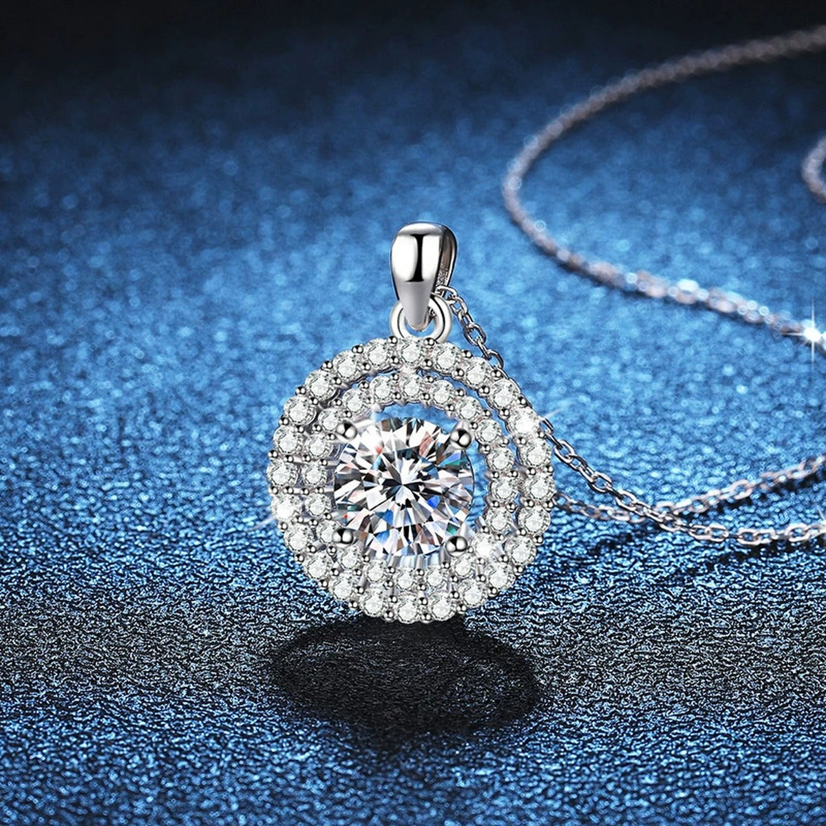 Double Halo Round Moissanite Pendant Necklace in Platinum-Plated S925 Sterling Silver blue background angled detail view