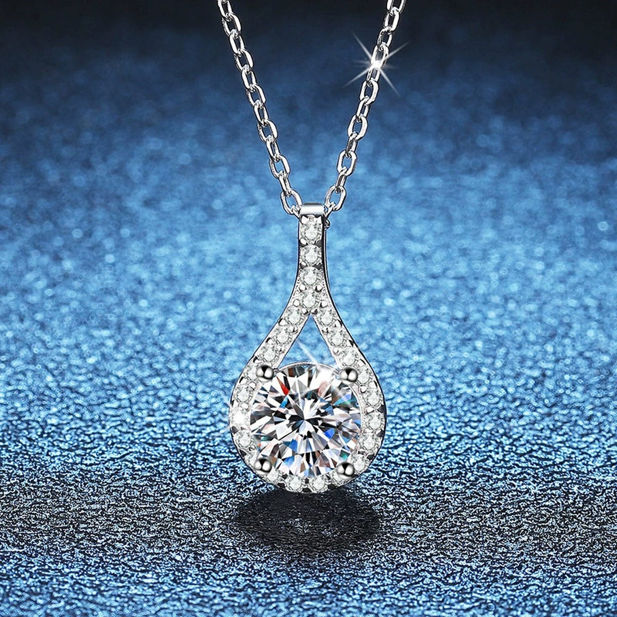 Pear Halo Moissanite Pendant Necklace in Platinum-Plated S925 Sterling Silver blue background close-up view