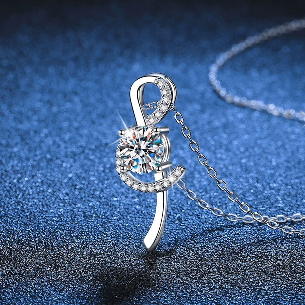 Crescent Moissanite Pendant Necklace in Platinum-Plated S925 Sterling Silver blue background angled detail view