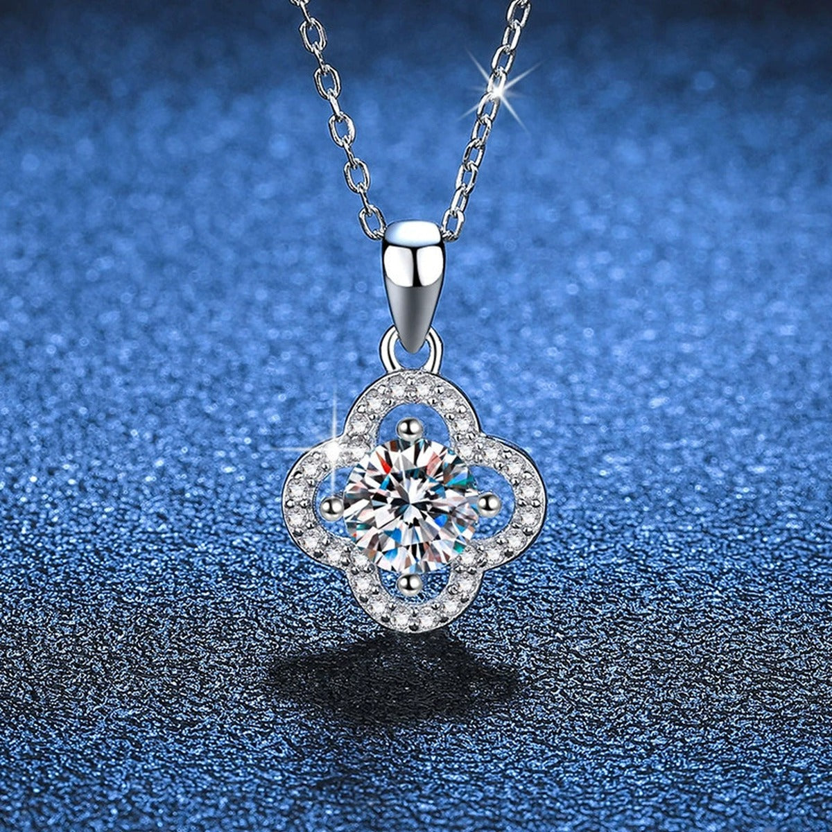 Four-Leaf Clover Halo Moissanite Pendant Necklace in Platinum-Plated S925 Sterling Silver blue background angled view