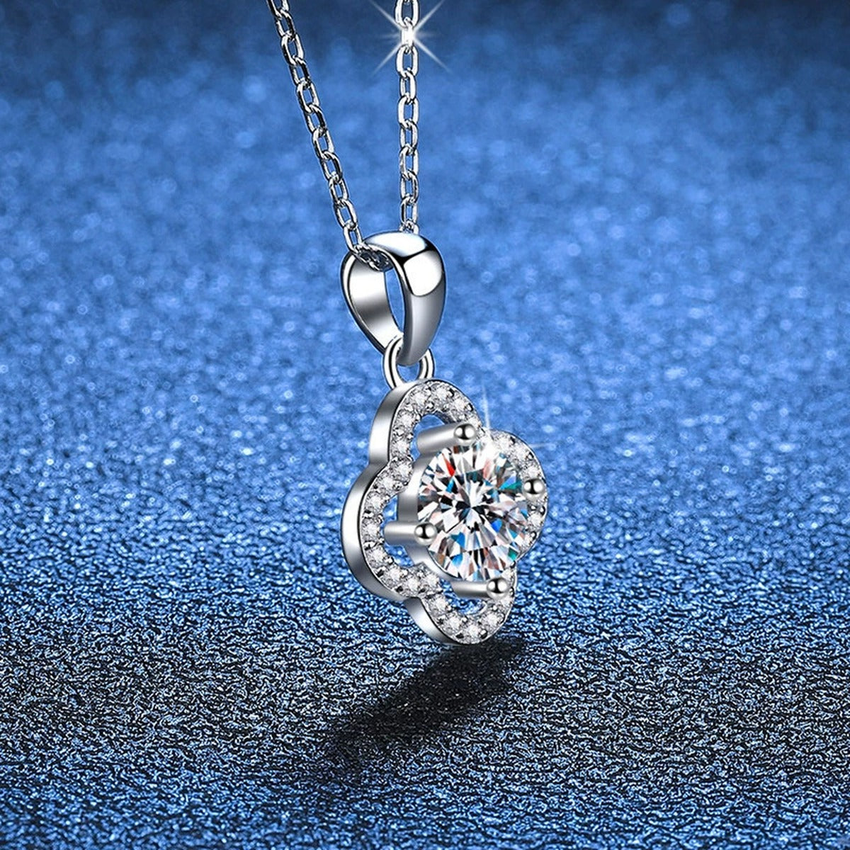 Four-Leaf Clover Halo Moissanite Pendant Necklace in Platinum-Plated S925 Sterling Silver blue background close-up view