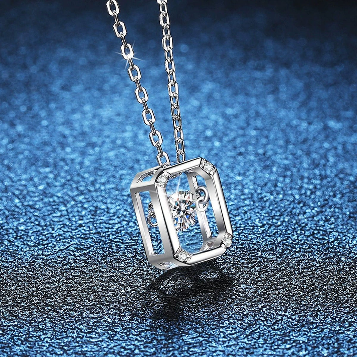 Emerald-Cut Halo Moissanite Pendant Necklace in Platinum-Plated S925 Sterling Silver blue background close-up view