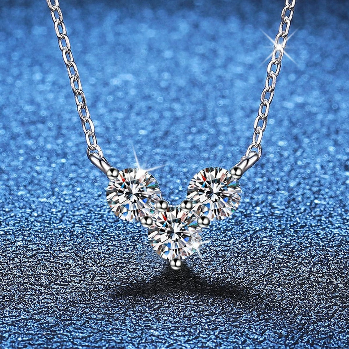 Three-Stone Moissanite Station Necklace in Platinum-Plated S925 Sterling Silver blue background close-up view