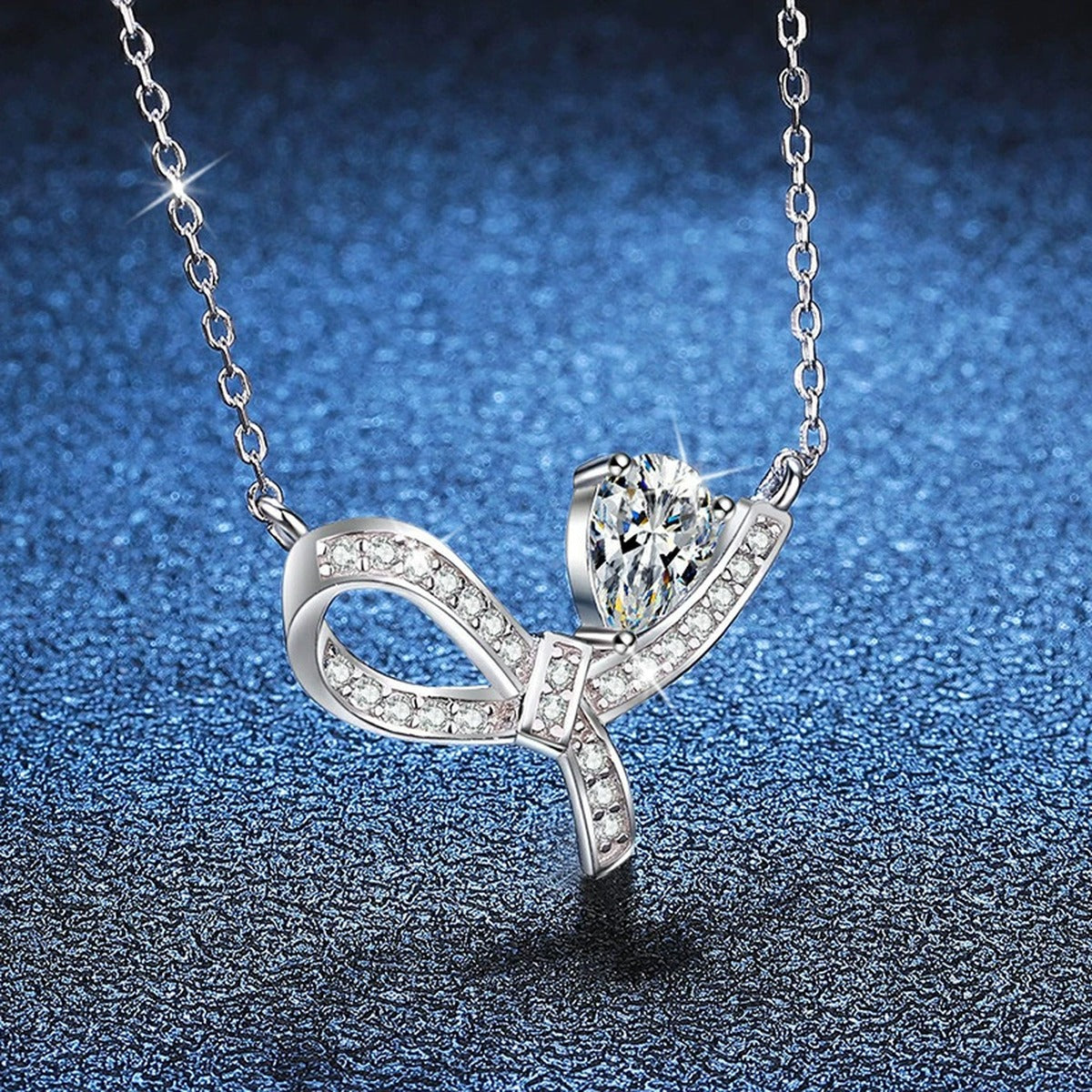 Pear-Cut Moissanite Ribbon Necklace in Platinum-Plated S925 Sterling Silver blue background angled view