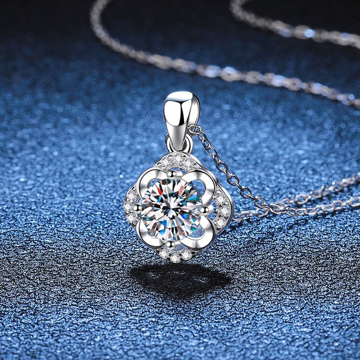 Round Floral Halo Moissanite Pendant Necklace in Platinum-Plated S925 Sterling Silver blue background angled view