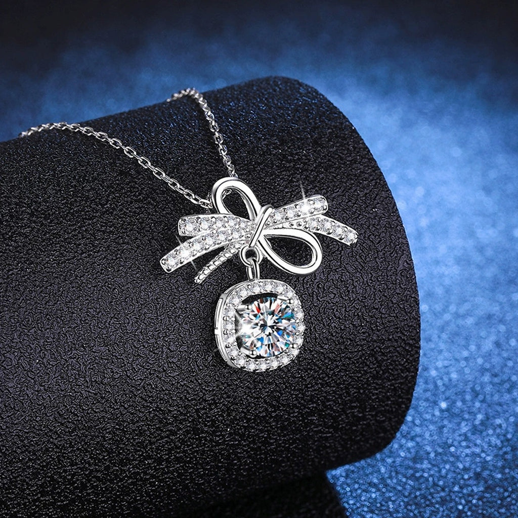 Bow Cushion Halo Moissanite Pendant Necklace in Platinum-Plated S925 Sterling Silver blue background angled view