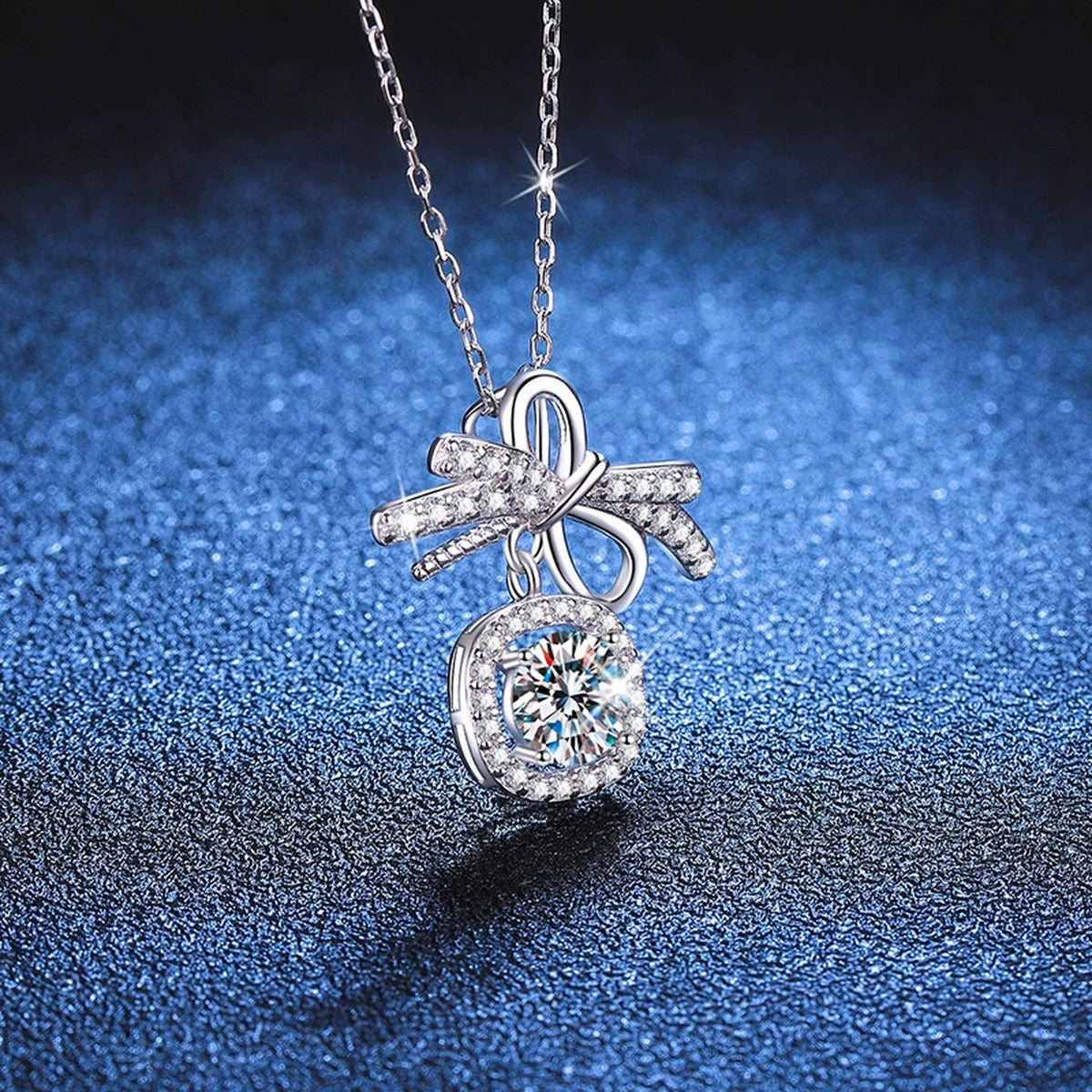 Bow Cushion Halo Moissanite Pendant Necklace in Platinum-Plated S925 Sterling Silver blue background close-up view
