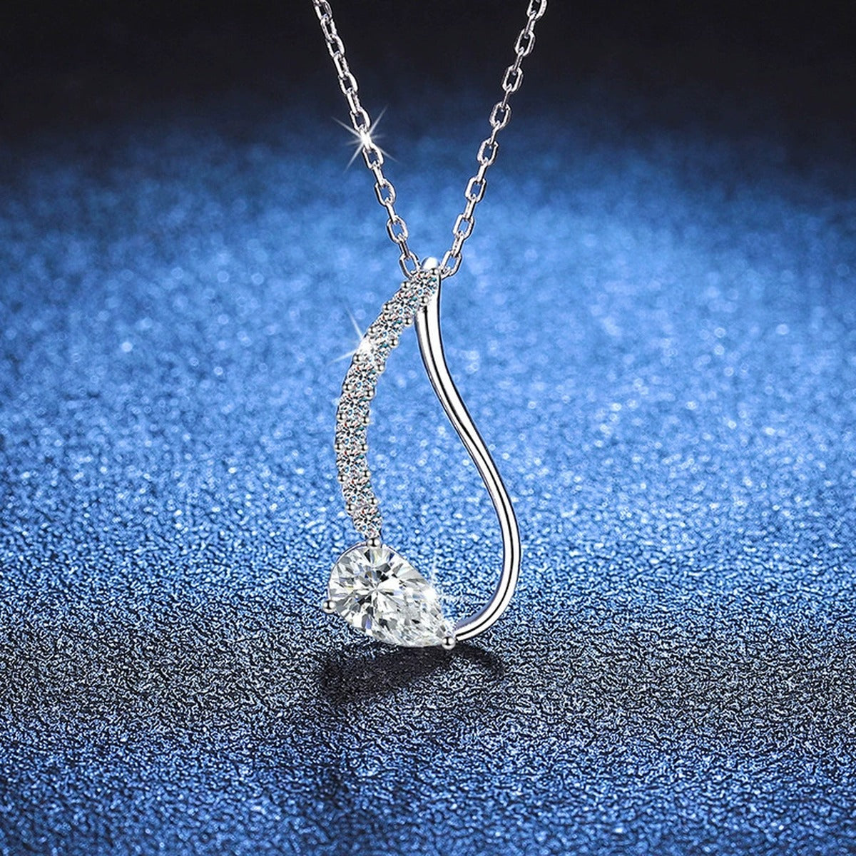 Pear-Cut Moissanite Drop Necklace in Platinum-Plated S925 Sterling Silver blue background angled view